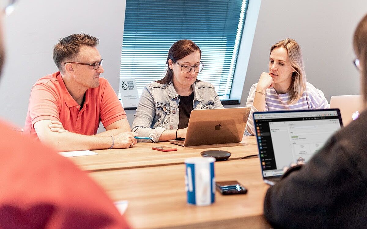 Personen sitzen am Tisch und besprechen Themen