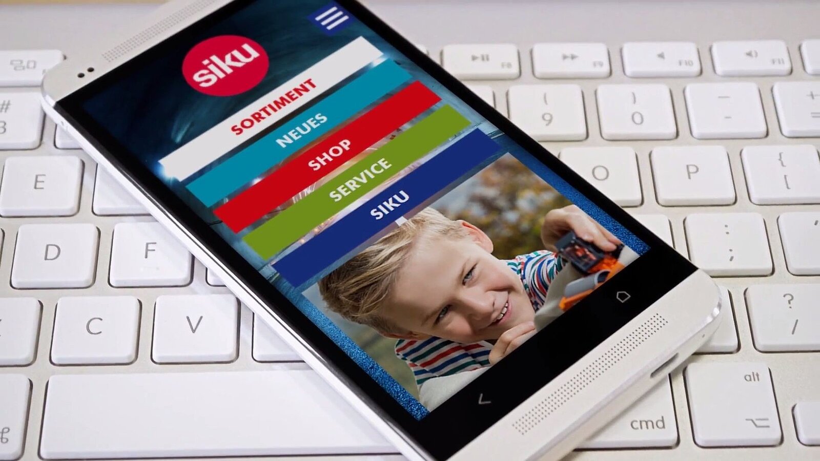 Smartphone mit Screenshot von der Siku Website liegt auf einer Tastatur
