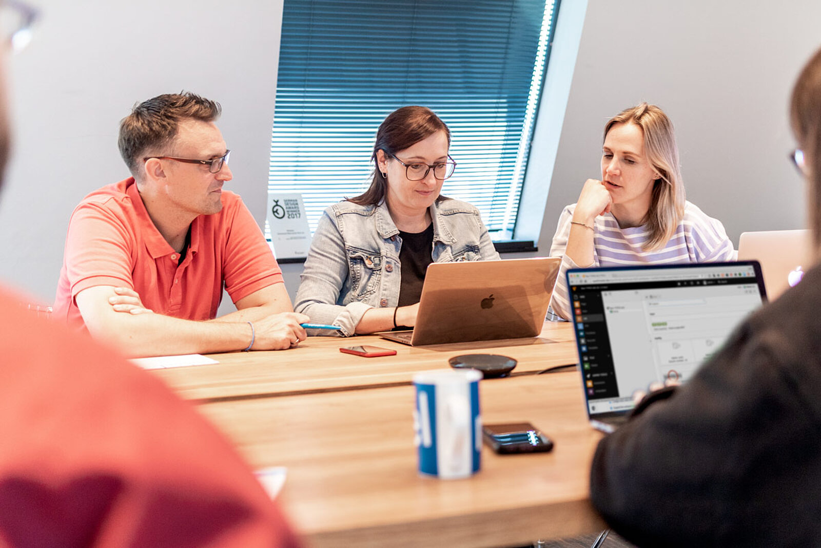 Personen sitzen am Tisch und besprechen Themen